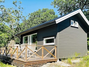 Une petite cabane dotée d’une terrasse et d’un espace salon extérieur.