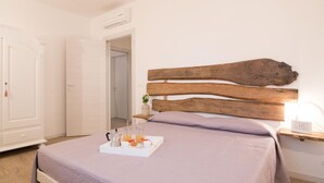 A bedroom with a bed, a bedside table with a lamp, and a tray with breakfast items. - Bright Apartment in a Farmhouse With Swimming Pool (Fermo)