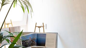 Un escritorio con un libro, un cuadro enmarcado y una planta.