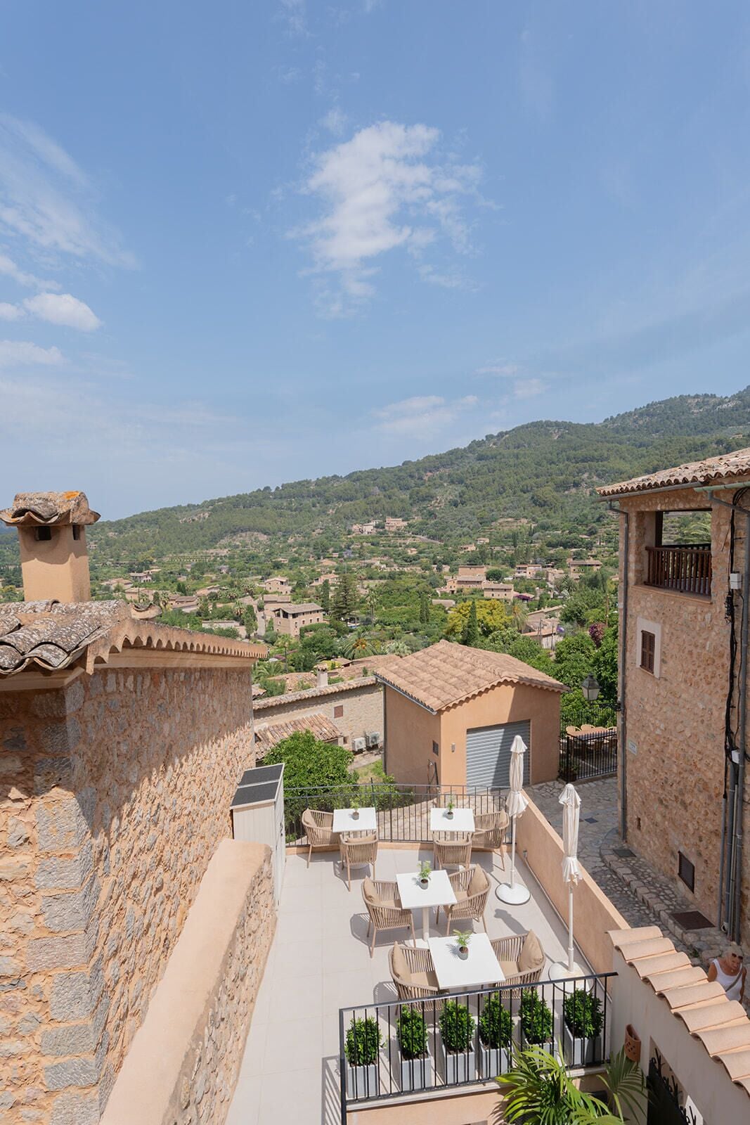Terraza en la azotea con mobiliario exterior y vistas a un paisaje montañoso.