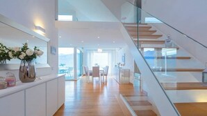 A modern interior with a wooden staircase, a kitchen area, and a dining space with a view. - The Great Beauty, beautiful property with amazing view on the lake of Como (Lombardia)