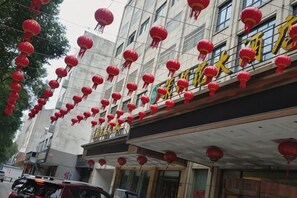 A building with multiple floors, red lanterns hanging from the exterior, and a sign with Chinese characters. - Huarong Jasmine Hotel (Huarong)