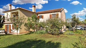A two-story house with a tiled roof, a chimney, and a small balcony. - Holiday apartment with air conditioning (Rovinj)