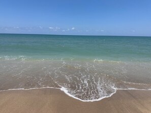 A beach with clear water and a sandy shore.