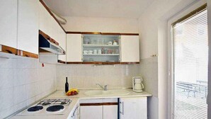 A compact kitchen with a gas stove, a sink, and a small refrigerator.