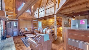 A log cabin interior with a living area featuring leather sofas, a coffee table, and a stone fireplace. - Avoid The Traffic Jams 7acres 360 Views 7b 4 5b (Sevierville)