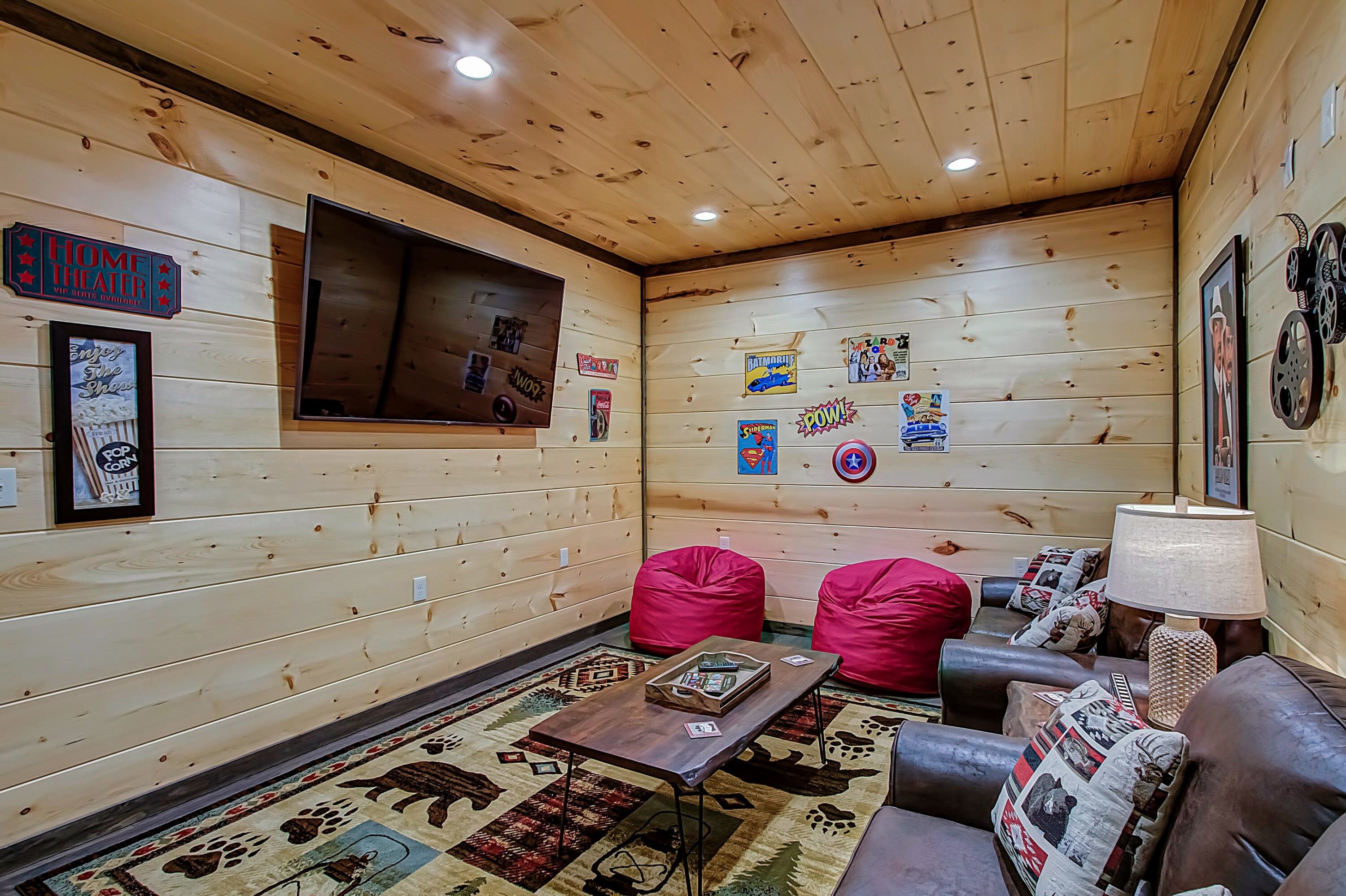 Une pièce chaleureuse avec des murs en bois, une grande fenêtre et une variété de posters et de décorations.