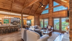 A spacious wooden cabin with a kitchen, dining area, and living room with large windows. - Luxury 3 2 5 Cabin Lake Views Theatre Gameroom (Bryson City)
