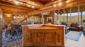 A spacious wooden interior with a large central island, dining area, and a cozy seating area with a view of the outdoors. - 47majestic Luxe 3bd 3 5ba w Spectacular Views (Sevierville)