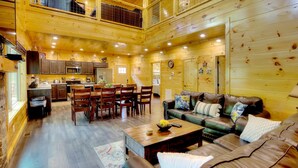 A spacious wooden cabin with a dining area, kitchen, and a cozy living room with leather furniture. - 5 Master Suites 5 6bath Cabin 5 min to Gsmnp (Gatlinburg)