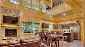 A spacious wooden cabin interior with a dining area, kitchen, and a fireplace. - 5 Master Suites 5 6bath Cabin 5 min to Gsmnp (Gatlinburg)