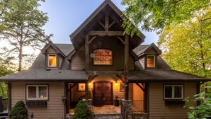 A two-story house with a prominent front porch, a large wooden door, and a small window above the door. - Lake Views Luxury Hottub Game Rm 5bed 4 5bath (Bryson City)