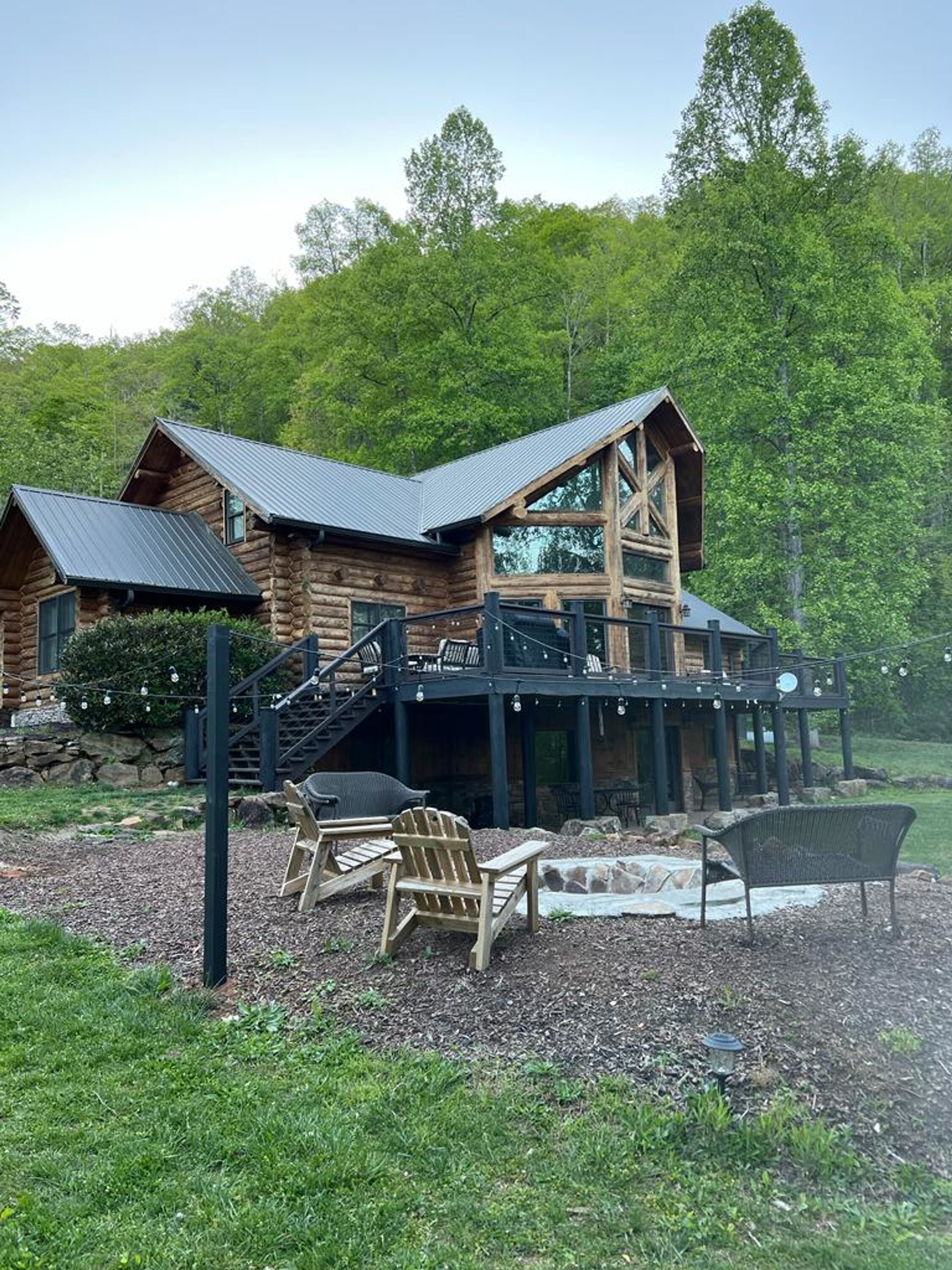 A log cabin with a balcony and outdoor seating area.