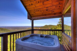 A hot tub on a wooden deck with a scenic view of hills and trees. - A Stellar 2bed 2bath Minutes to Parkway (Sevierville)