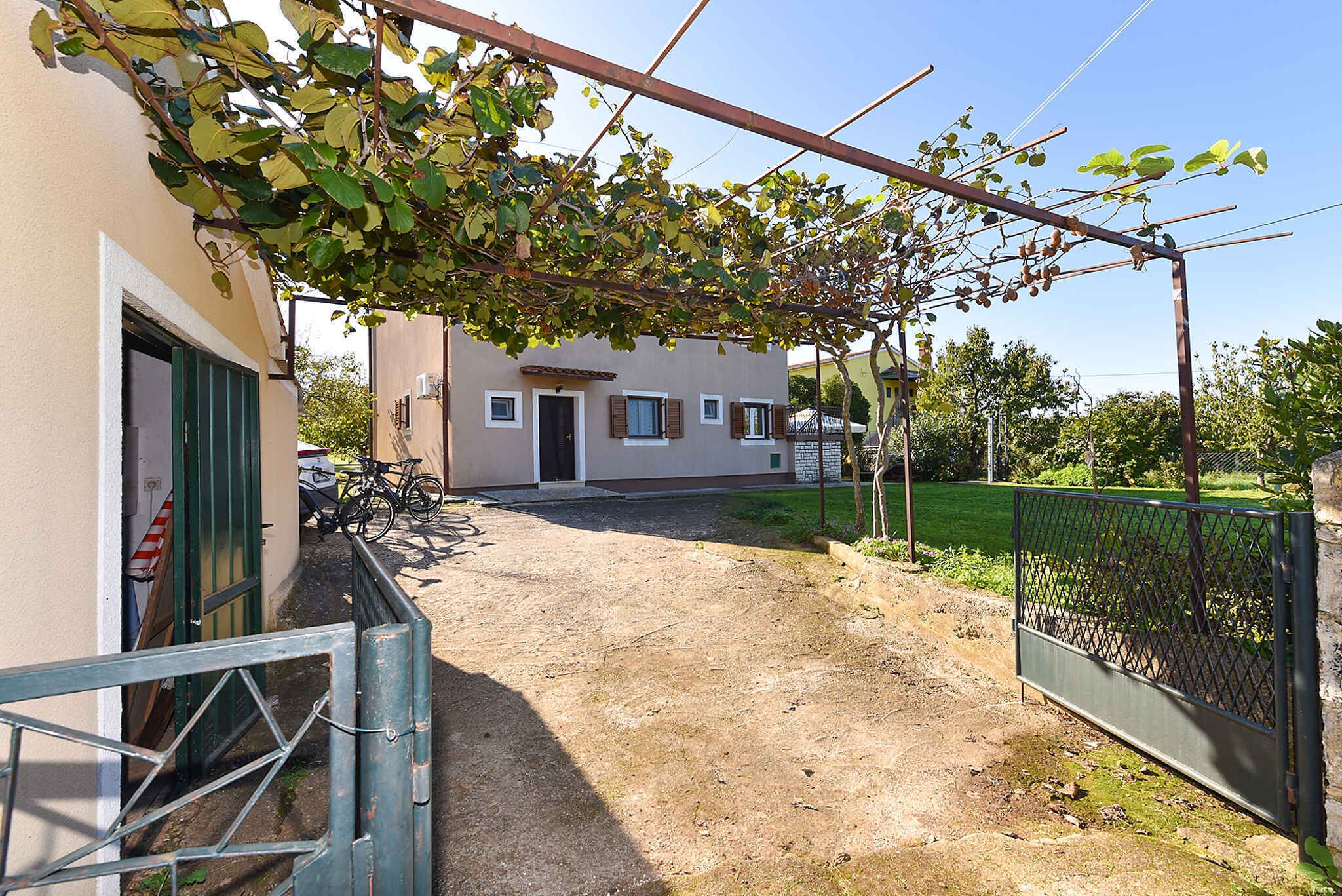 A building with a dirt pathway leading to a gated entrance.