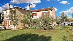 A two-story house with a tiled roof, a chimney, and a small balcony. - Holiday apartment with air conditioning (Rovinj)