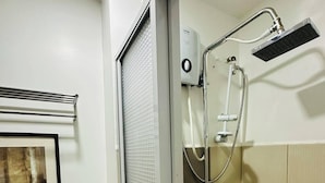 A small, enclosed shower stall with a handheld showerhead and a handheld faucet. - Taguig 1 Bedroom with Balcony Near Bgc (Taguig)