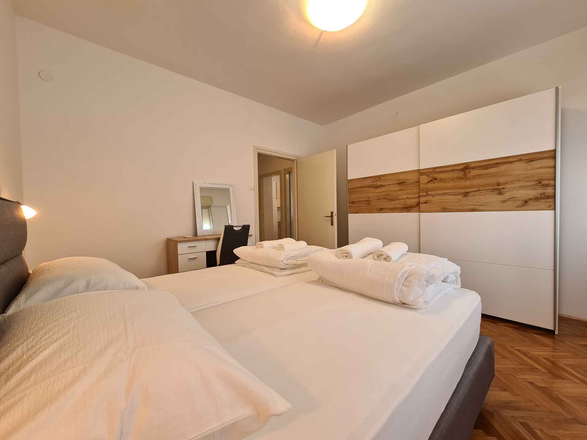 Une chambre à coucher moderne avec un grand lit, une table de chevet, un miroir et une armoire.