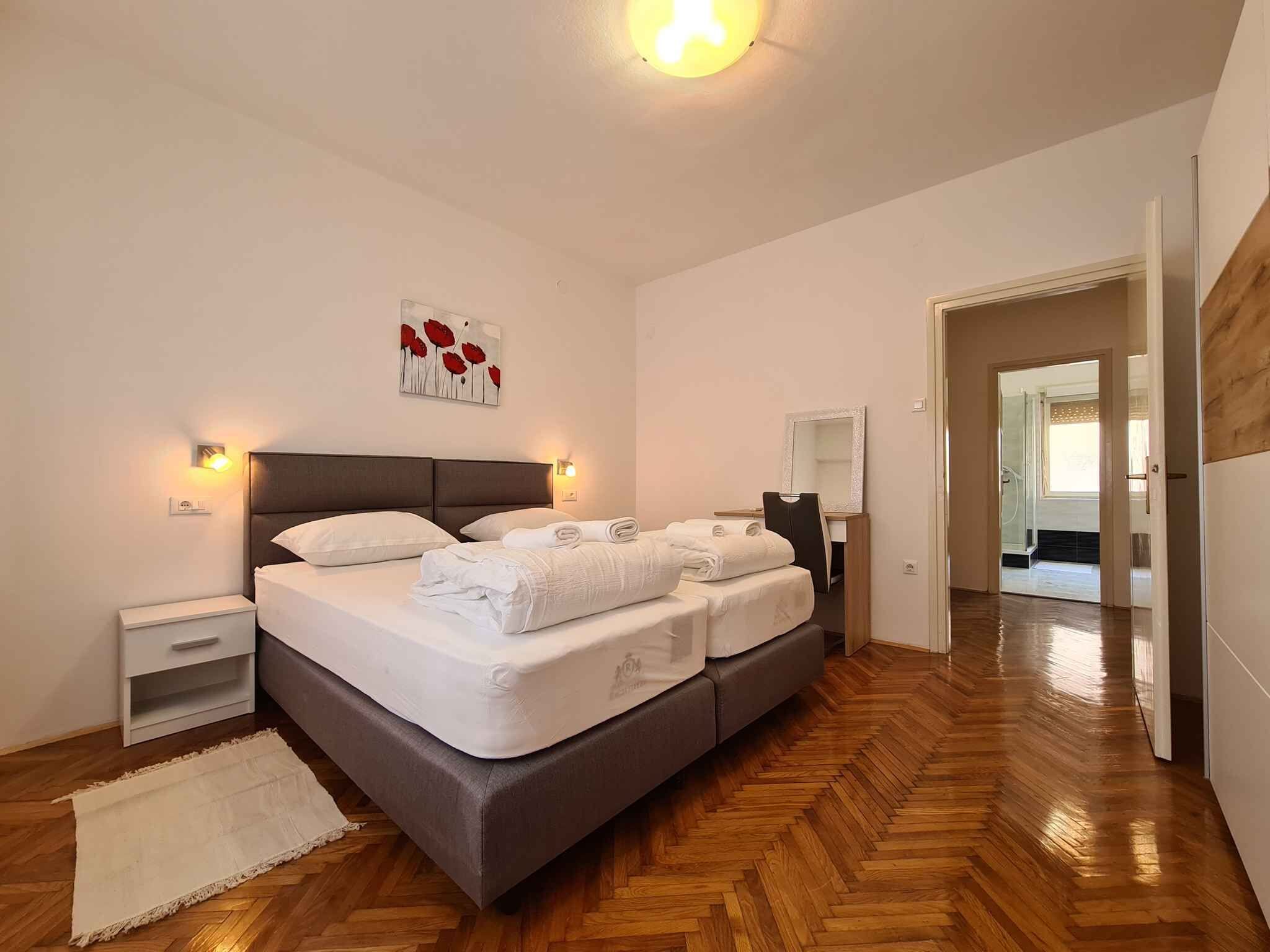 Una camera da letto con un letto grande, comodini, uno specchio e un pavimento in legno.