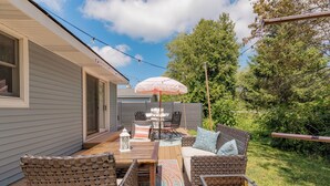 An outdoor patio with a table, chairs, and a hanging umbrella.