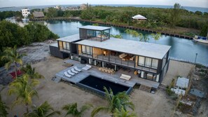 Une maison moderne à deux étages, dotée d’une grande terrasse, d’une piscine et offrant une vue sur l’océan.