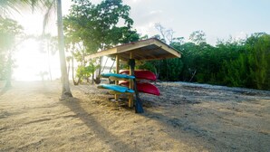 Une plage avec un abri en bois et des kayaks.