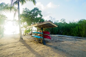 Une plage avec un abri en bois et des kayaks.