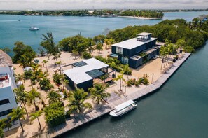Una propiedad frente al agua con un edificio moderno, un muelle y un bote.