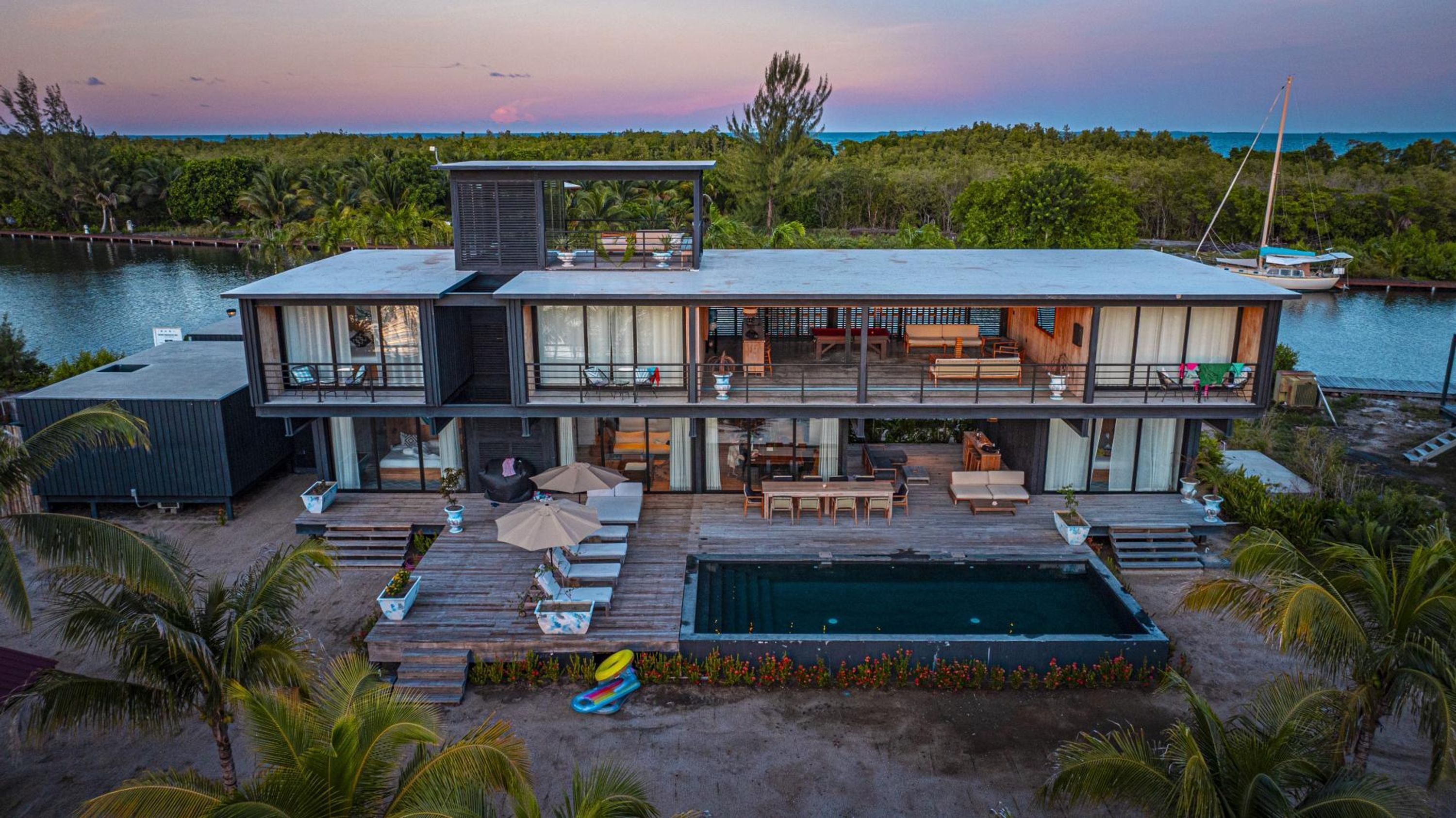 Una casa moderna de dos pisos con piscina, terraza y vistas al océano.