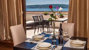 A dining table set for two with a view of a lake and hills. - Holiday apartment with air conditioning and sea view (Crikvenica)