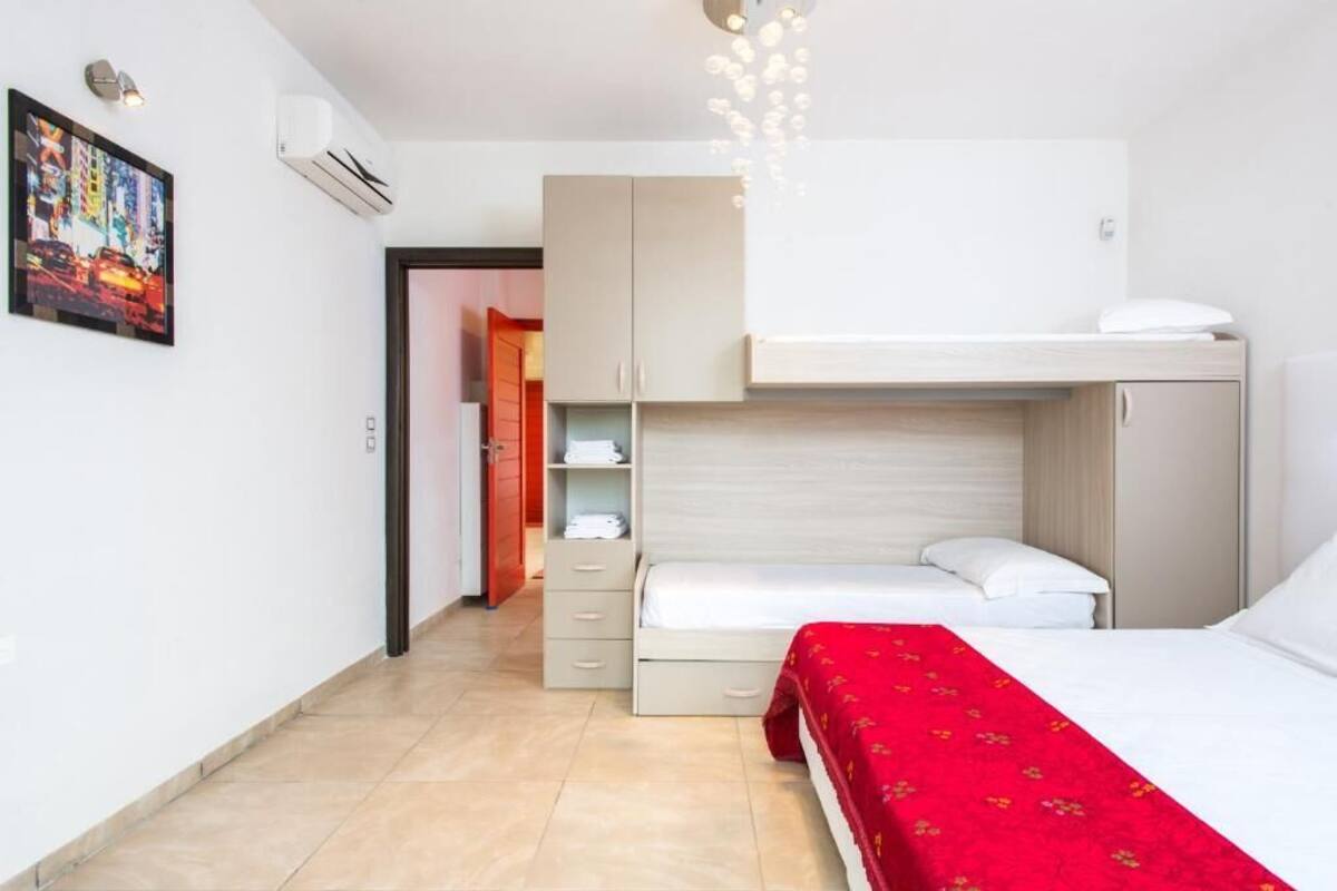 A compact hotel room with a bunk bed, a small desk, and a wardrobe.