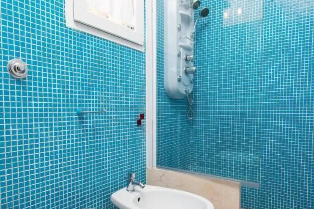 A bathroom with two toilets, a sink, and a shower.