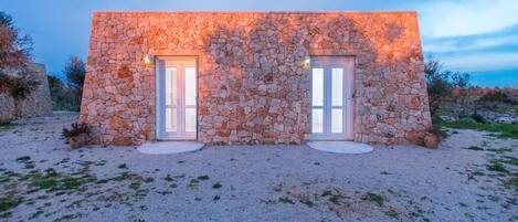 Un edificio de piedra con dos puertas y un camino de grava.