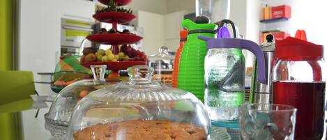 A glass display case with a covered dessert, a pitcher, and a glass with a drink.