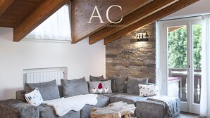 A modern living room with a sectional sofa, a wooden coffee table, and a stone accent wall. - Charme Mountain Maison (Temu)
