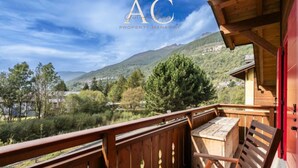 A wooden deck with a table and chairs, overlooking a mountainous landscape. - Charme Mountain Maison (Temu)