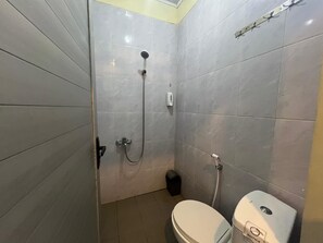 A small bathroom with a toilet, a shower, and a hand dryer. - Kampung Karuhun Eco Green Park Sumedang (Citengah)
