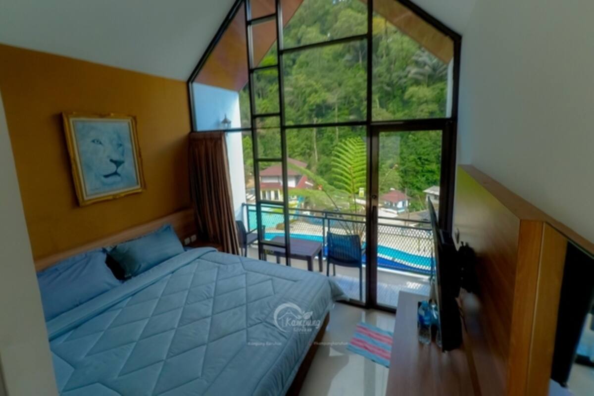 Ein Schlafzimmer mit einem großen Bett, einem Gemälde an der Wand und Blick auf Pool und Grünfläche.
