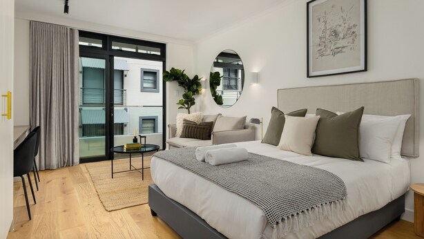 Quarto moderno com uma cama grande, uma escrivaninha e um sofá.
