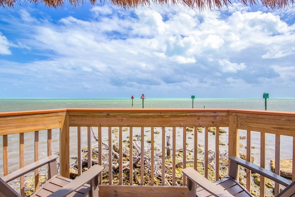 A wooden deck with a view of the ocean and beach.