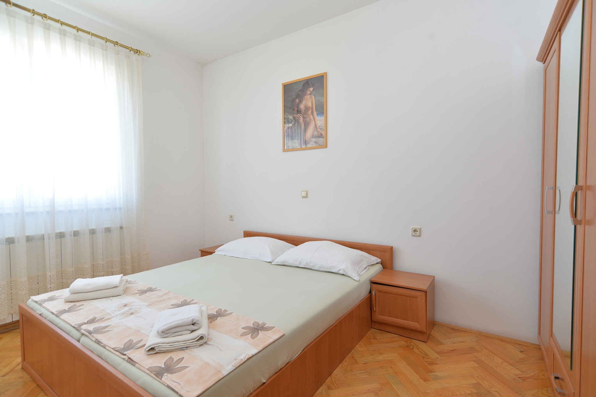 Ein Schlafzimmer mit Bett, Nachttisch, Kleiderschrank und einem Bild an der Wand.