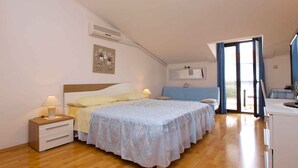 A bedroom with a bed, bedside tables, a desk, a chair, a window, and a door. - Studio with air conditioning and balcony (Rovinj)