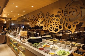A buffet area with various food items and a decorative wall with floral patterns. - Green World Taipei Station (Taipei)
