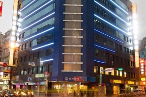 A multi-story building with illuminated signage and a busy street in front. - Green World Taipei Station (Taipei)