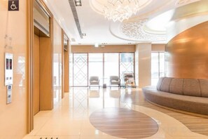 A hotel lobby with a reception desk, seating area, and large windows. - Green World Taipei Station (Taipei)