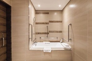 A modern bathroom with a large bathtub, grab bars, and a towel rack. - Green World Taipei Station (Taipei)