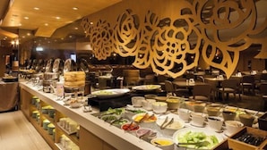 A buffet area with a variety of food items and a decorative wall with intricate cut-out designs. - Green World Taipei Station (Taipei)