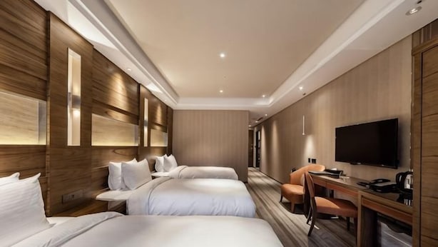 A hotel room with two beds, a desk, a chair, a flat-screen TV, and a coffee machine. - Green World Taipei Station (Taipei)