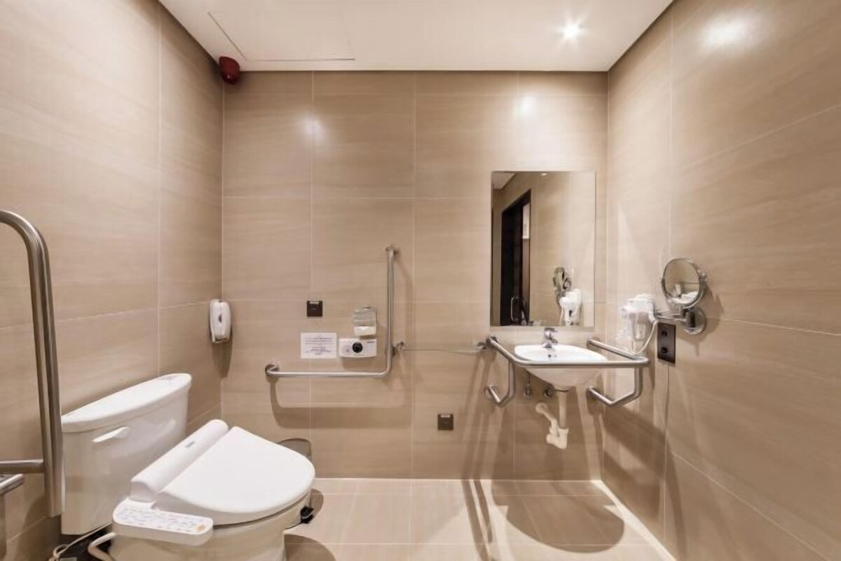 Uma casa de banho moderna com sanita, lavatório e chuveiro.