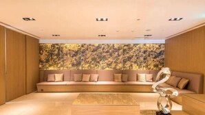 A modern interior with a sofa, a metallic sculpture, and a patterned wall. - Green World Taipei Station (Taipei)